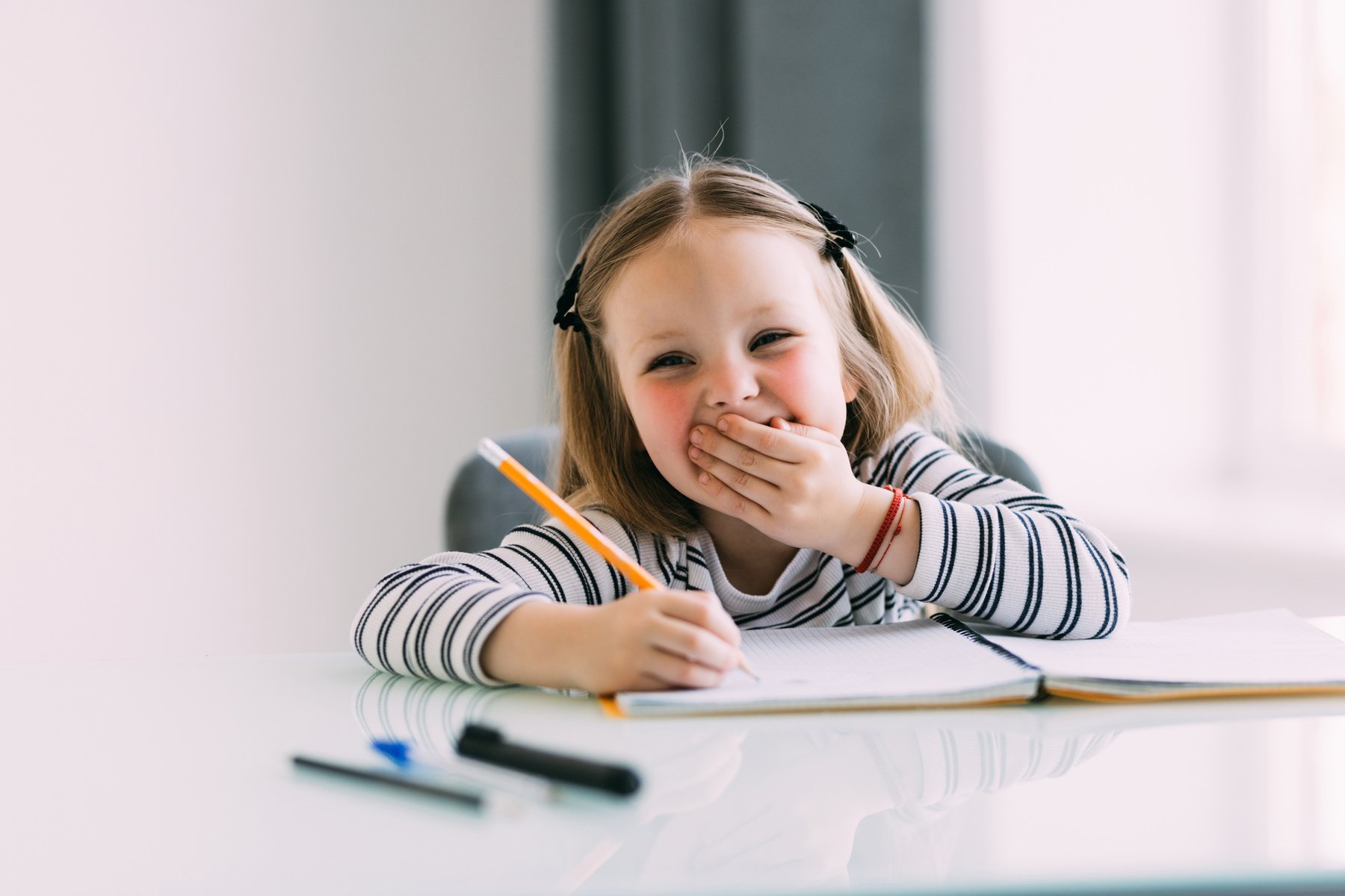 Little girl drawing at home and smile